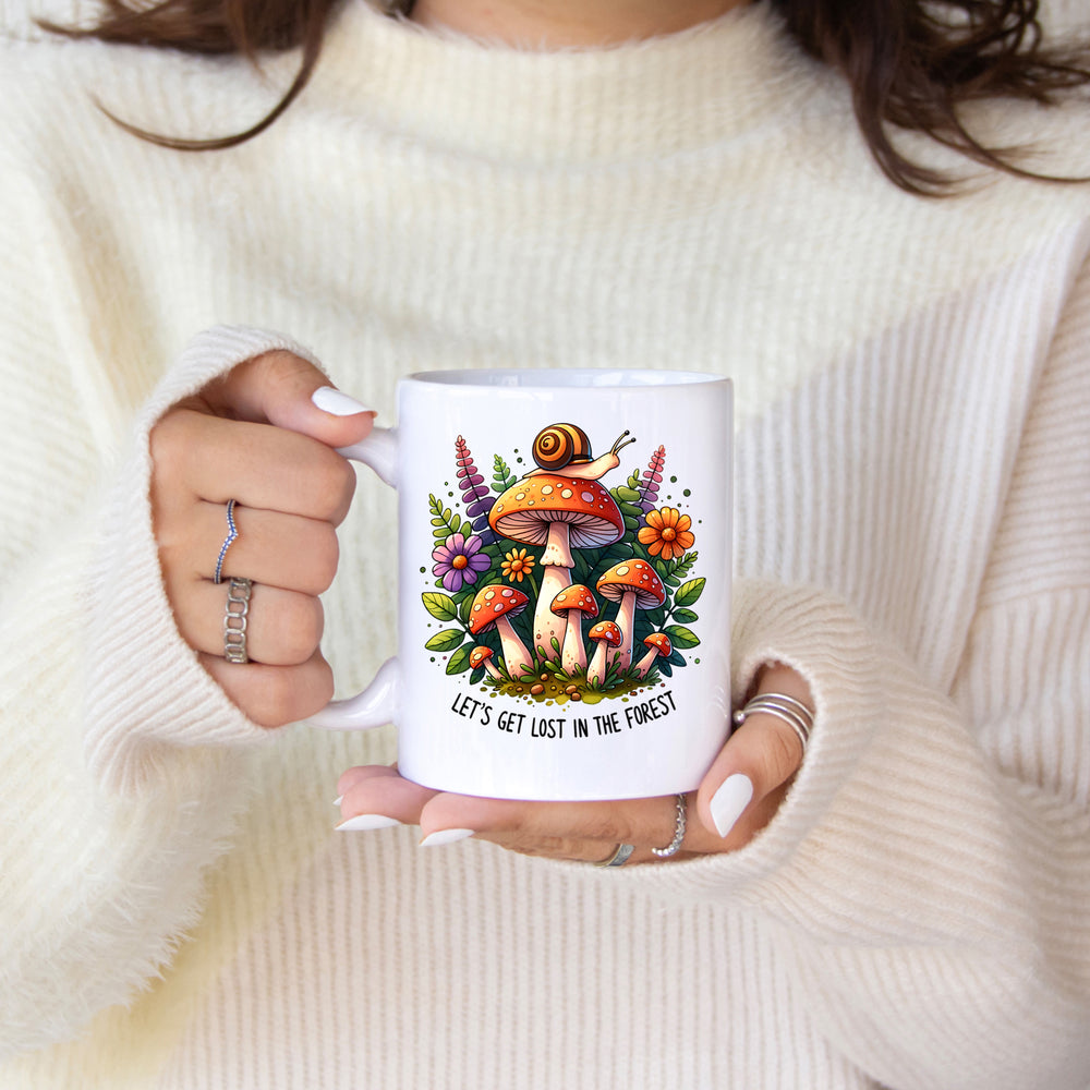Person holding a mug with a forest-themed design and text