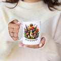 Person holding a mug with a forest-themed design and text