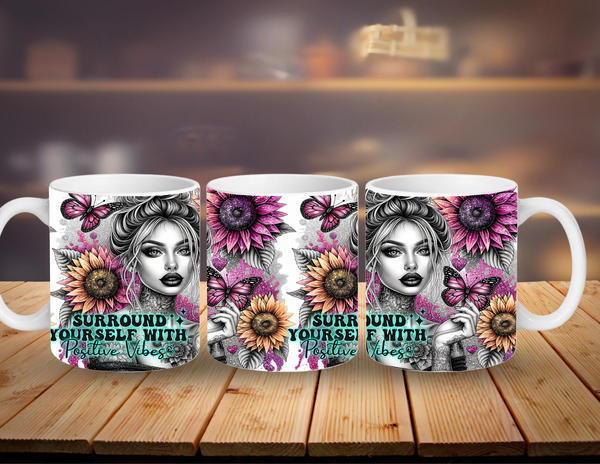 Three mugs with artistic designs and text on a wooden surface.