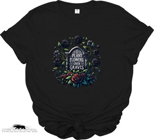 Black t-shirt with floral design and text 'Plant Flowers Over Graves' on a white background
