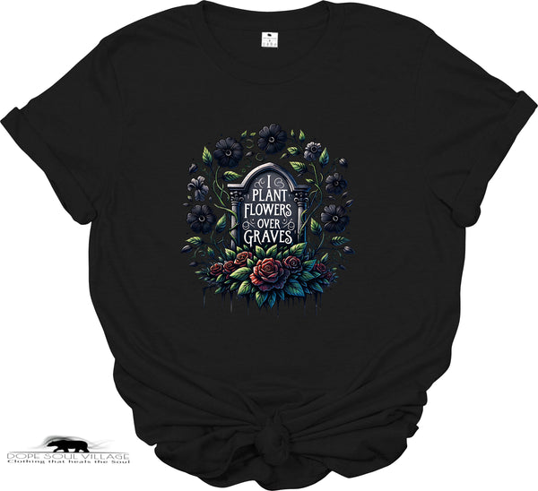 Black t-shirt with floral design and text 'Plant Flowers Over Graves' on a white background