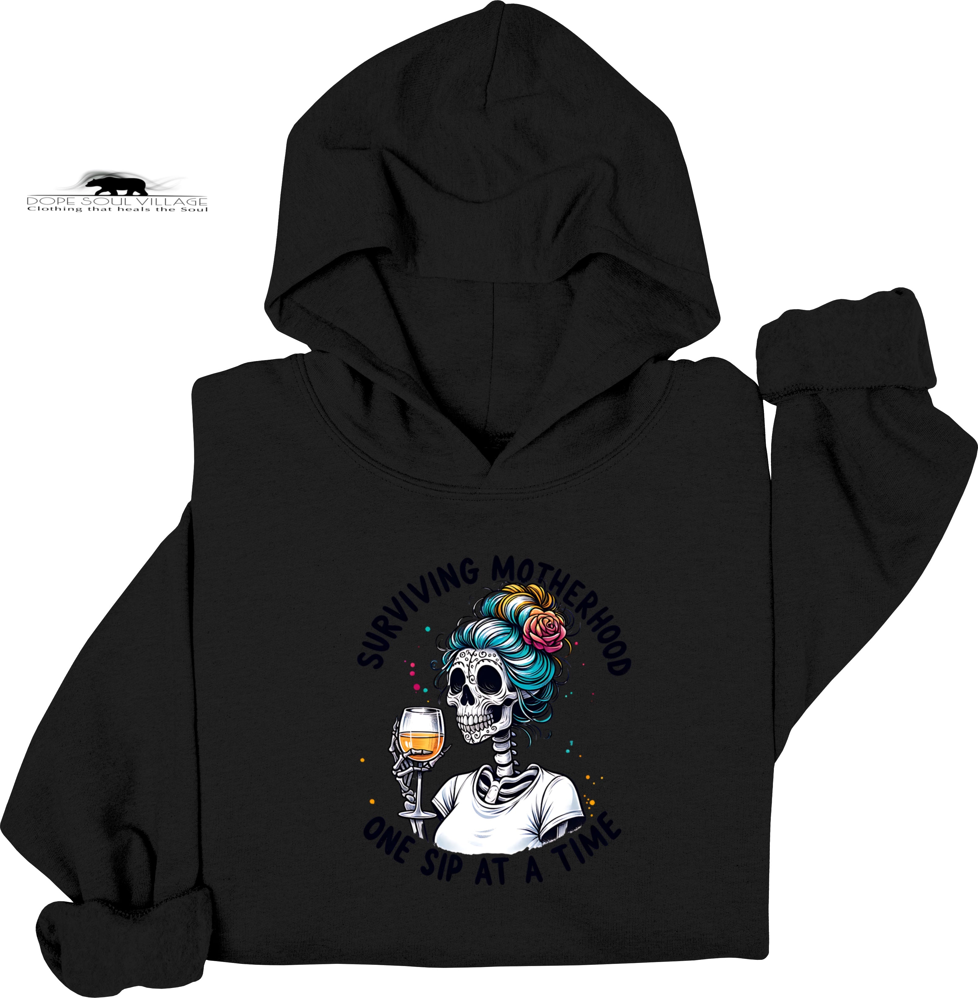 Black hoodie with a skeleton design holding a glass of wine and text 'Surviving Motherhood one sip at a time' on a white background.