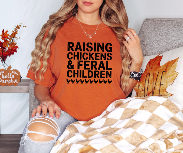Person wearing an orange t-shirt with text, sitting on a couch with autumn decorations.