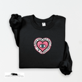 Black sweatshirt with a pink heart design featuring an eye and text on a white background