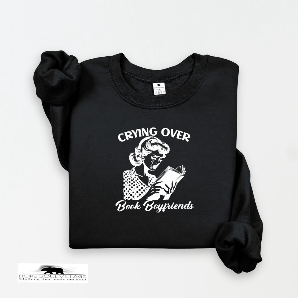 Black sweatshirt with graphic and text 'Crying Over Book Boyfriends' on a white background