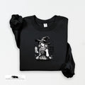 Black sweatshirt with a graphic of a witch and text on a white background