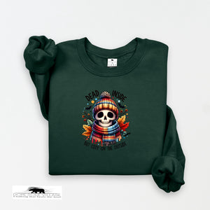Green sweatshirt with a skull design and text on a white background