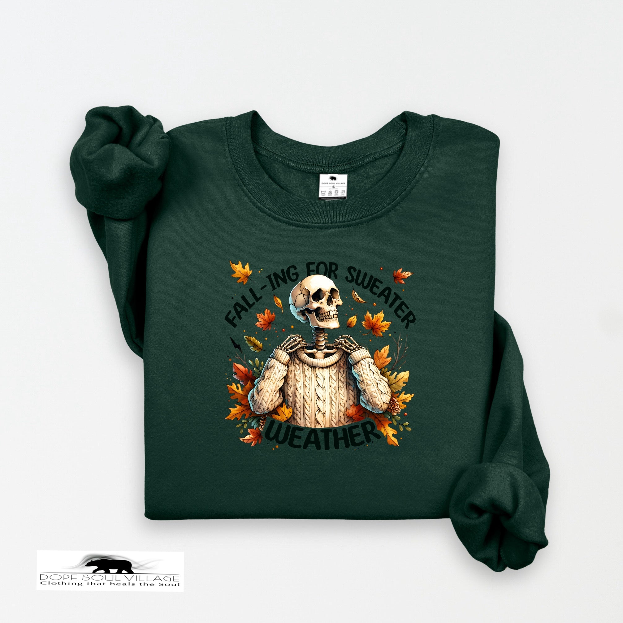 Green sweatshirt with a skeleton and autumn leaves design on a white background