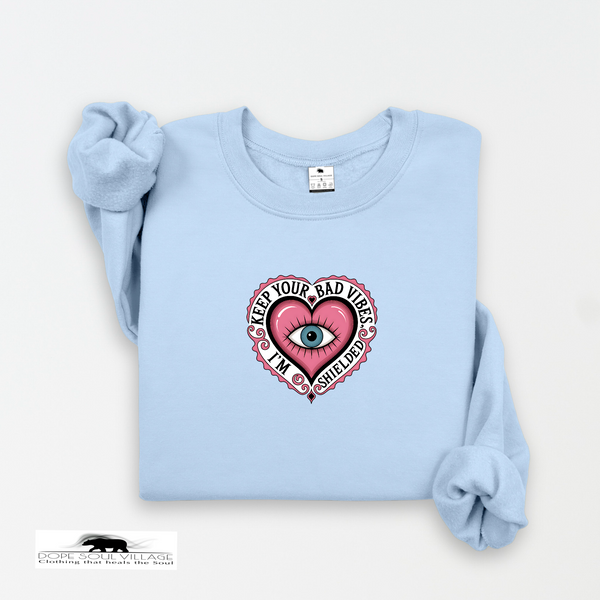 Light blue sweatshirt with a pink heart graphic and text on a white background