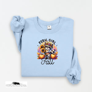 Light blue sweatshirt with a raccoon graphic and 'Feral Girl Fall' text on a white background