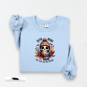 Light blue sweatshirt with a skull design and text on a white background