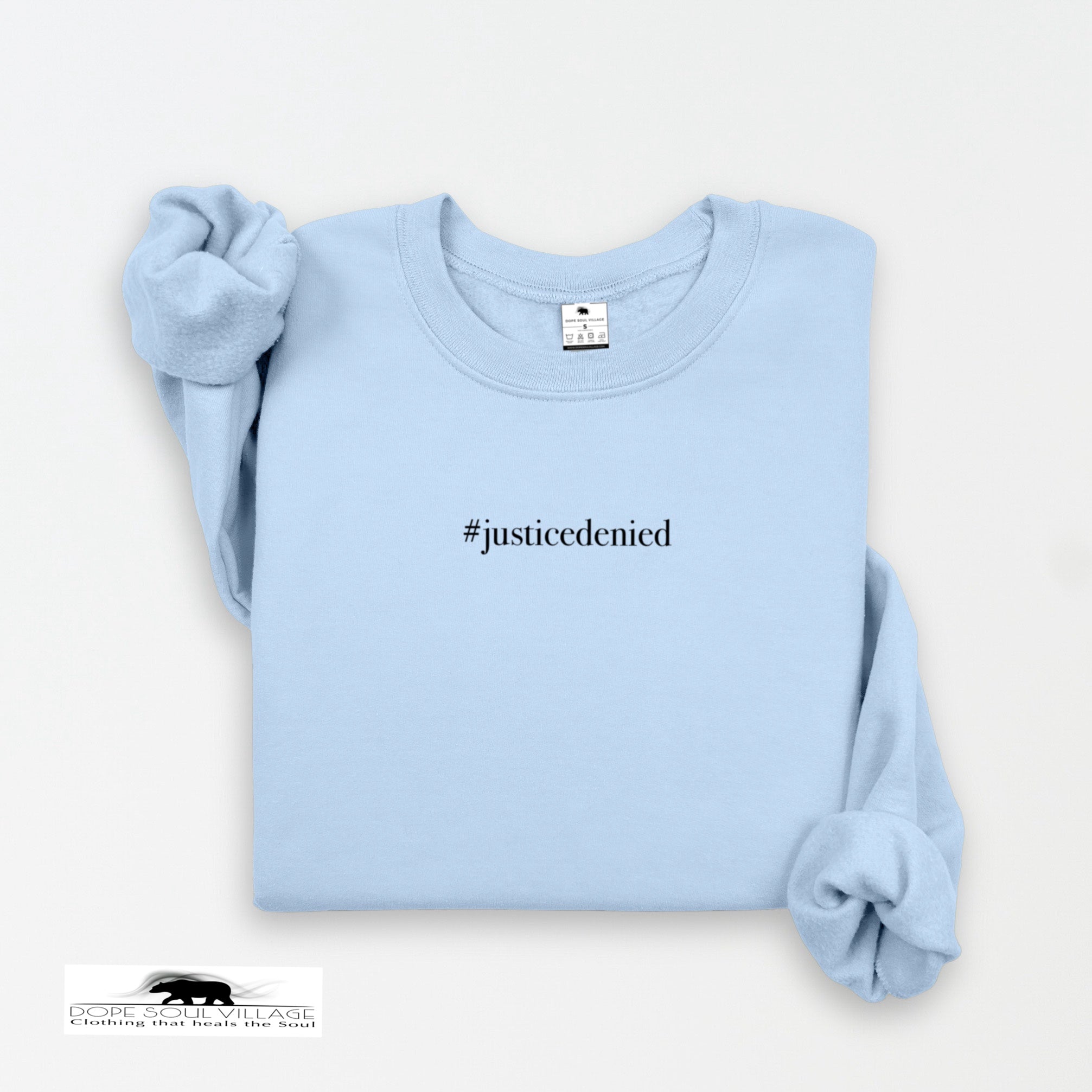Light blue sweatshirt with '#justicedenied' text on a white background rebecca goodwin