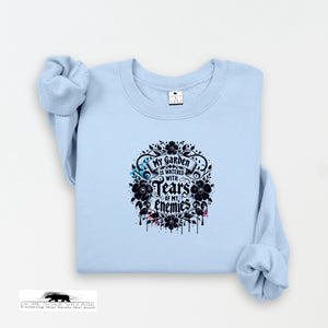 Light blue sweatshirt with black floral design and text on a white background