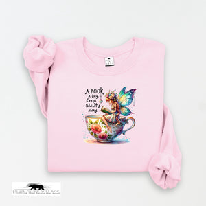 Pink sweatshirt with a fairy design and text on a white background