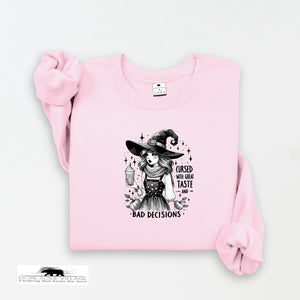 Pink sweatshirt with a witch graphic and text on a white background