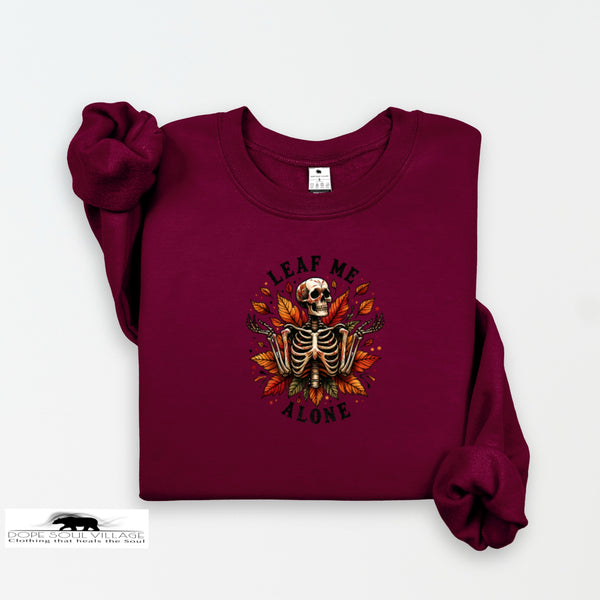 Maroon sweatshirt with a skeleton design and 'Leave Me Alone' text on a white background