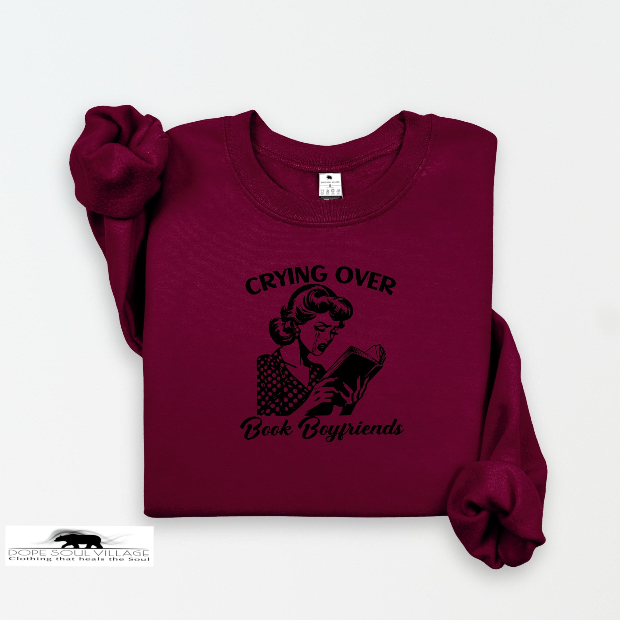 Maroon sweatshirt with graphic and text 'Crying Over Book Boyfriends' on a white background