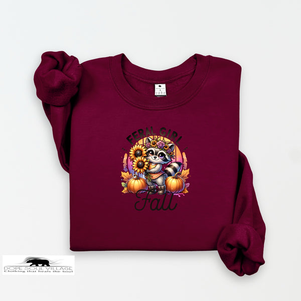 Maroon sweatshirt with a raccoon and fall-themed design on a white background