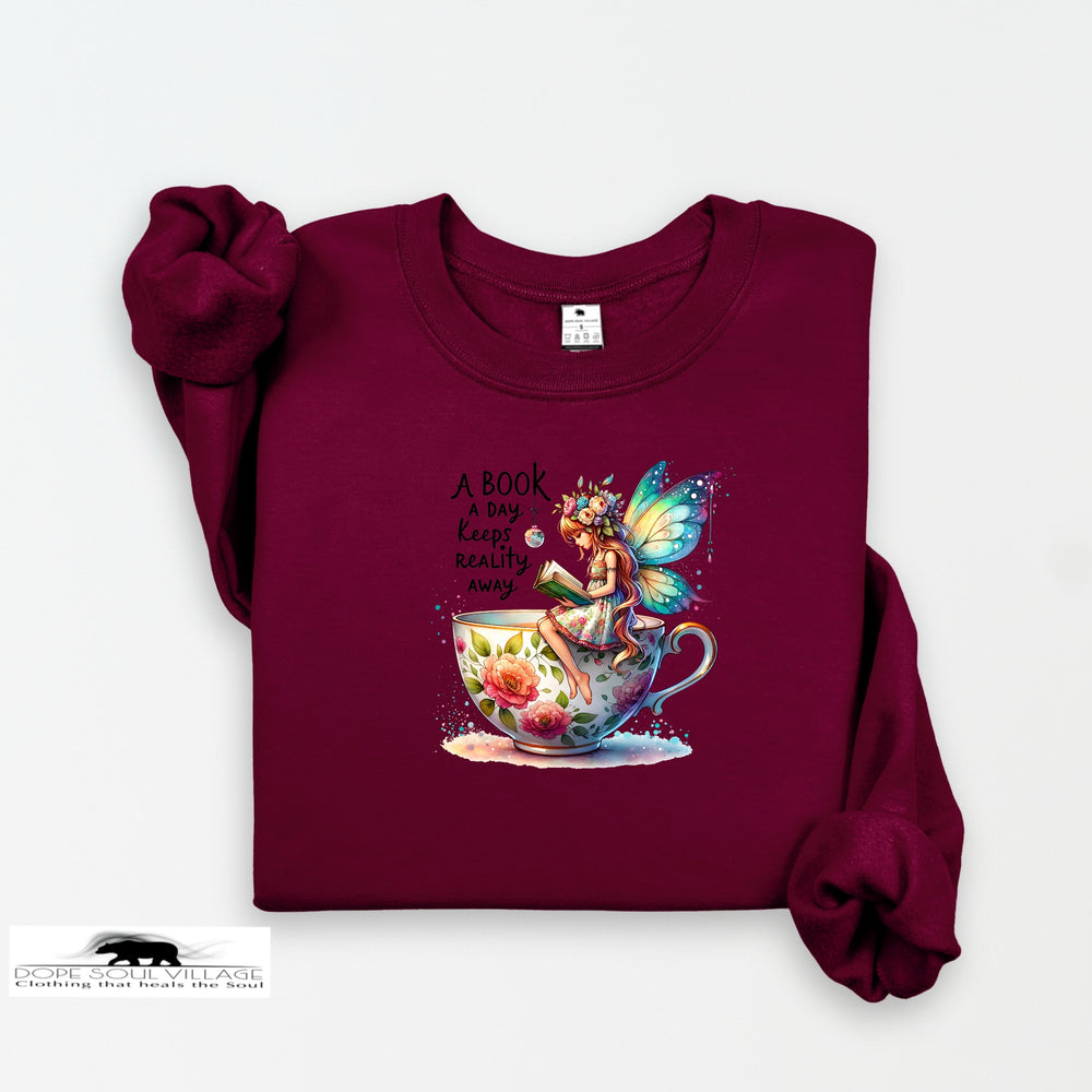 Maroon sweatshirt with fairy and book design on a white background