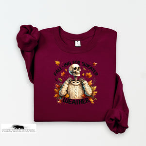 Maroon sweatshirt with skeleton wearing a sweater and 'falling for sweater weather' text on a white background