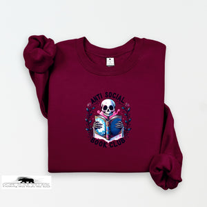 Maroon sweatshirt with a skull reading a book graphic and 'Anti Social Book Club' text on a white background.