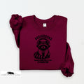 Maroon sweatshirt with raccoon graphic and text on a white background