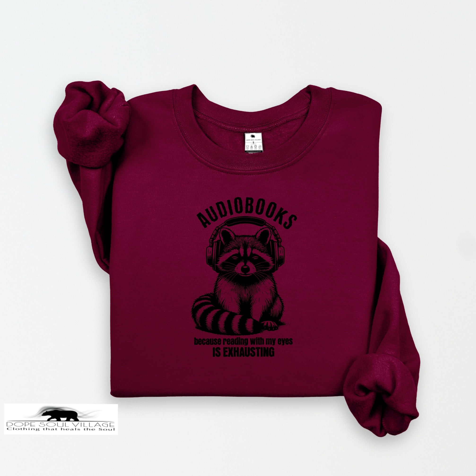 Maroon sweatshirt with raccoon graphic and text on a white background
