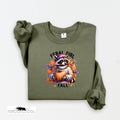 Green sweatshirt with a raccoon holding a pumpkin and 'Feral Girl Fall' text on a white background