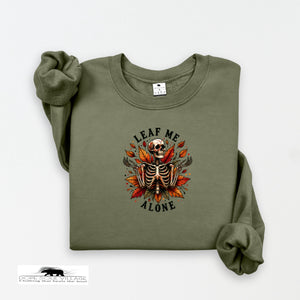 Green sweatshirt with skeleton and leaf design on a white background