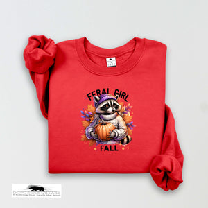 Red sweatshirt with a raccoon holding a pumpkin and 'Feral Girl Fall' text on a white background.