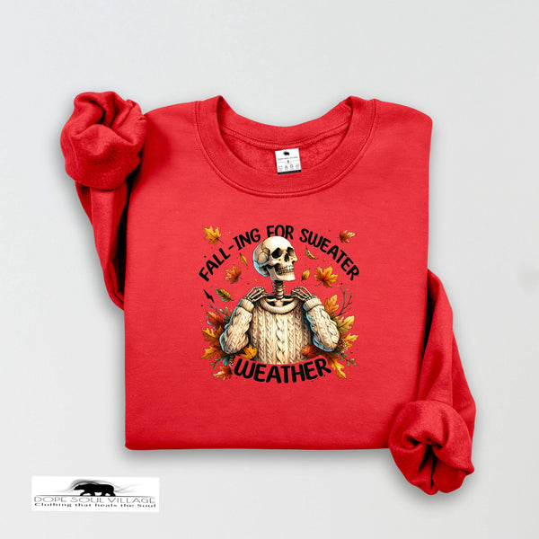 Red sweatshirt with skeleton design and text 'Fall-ing for Sweater Weather' on a light gray background.
