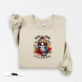 Beige sweatshirt with a skull design and text on a white background