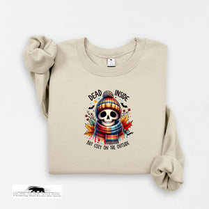 Beige sweatshirt with a skull design and text on a white background