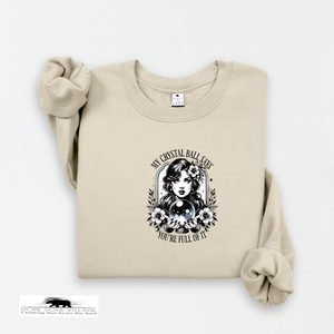Beige sweatshirt with a graphic design of a woman holding a crystal ball on a white background