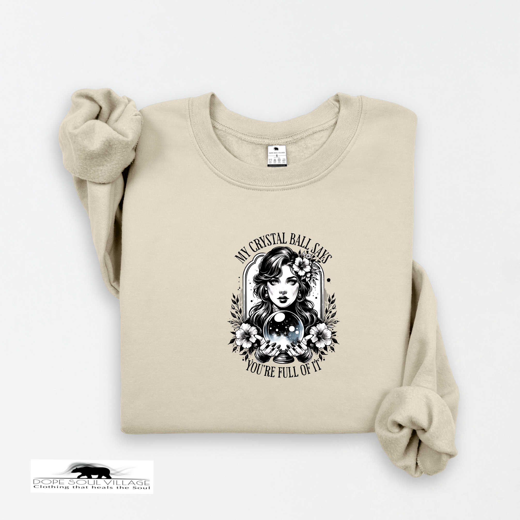 Beige sweatshirt with a graphic design of a woman holding a crystal ball on a white background