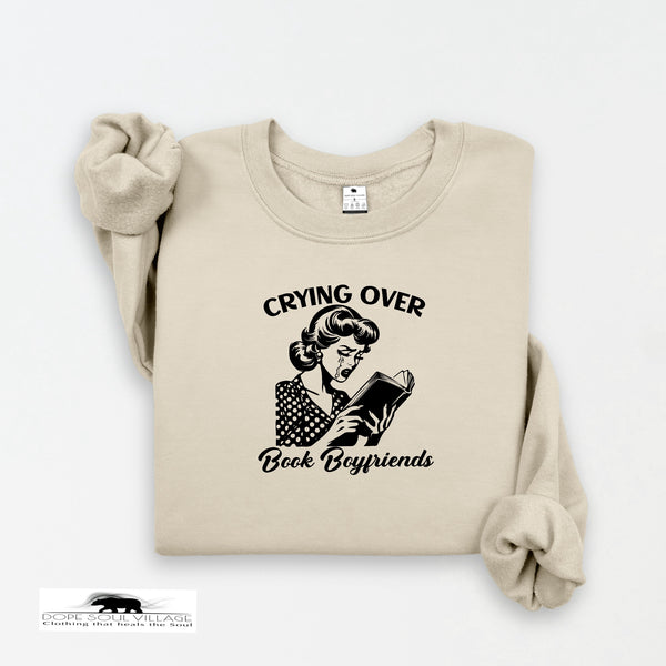 Beige sweatshirt with graphic and text 'Crying Over Book Boyfriends' on a white background
