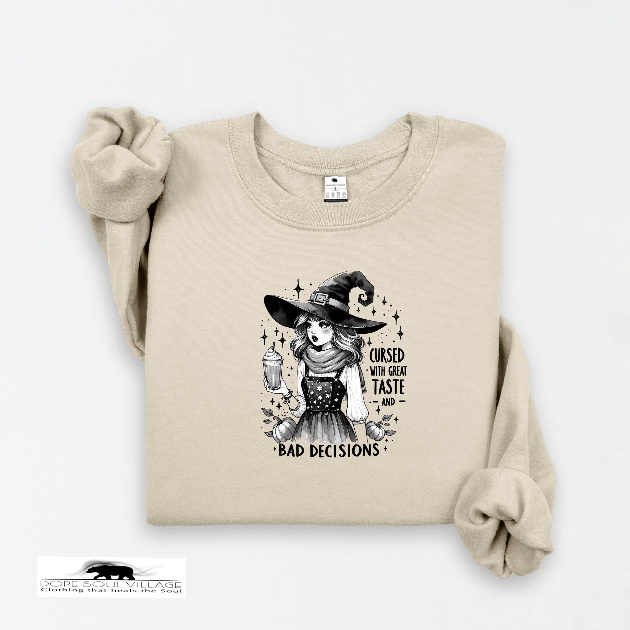 Beige sweatshirt with a witch graphic and text on a white background
