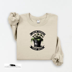 Beige sweatshirt with graphic design and text 'I Grow Things That Bite' on a white background
