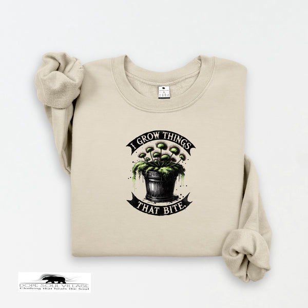Beige sweatshirt with graphic design and text 'I Grow Things That Bite' on a white background