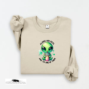 Beige sweatshirt with a cartoon alien design and text on a white background