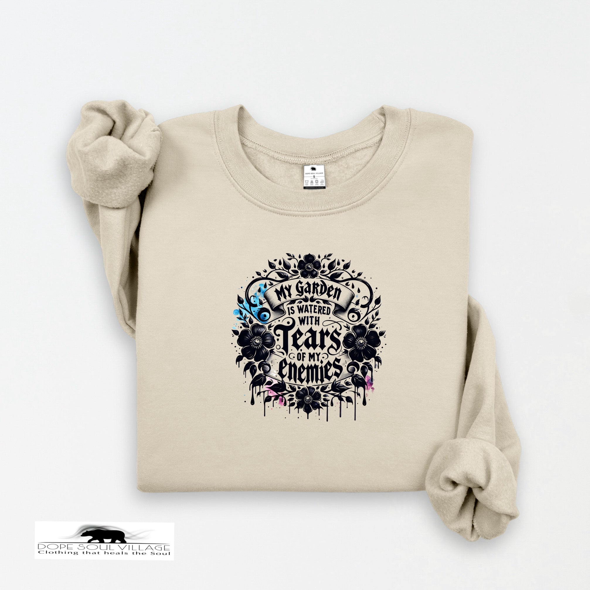 Beige sweatshirt with black floral design and text on a white background