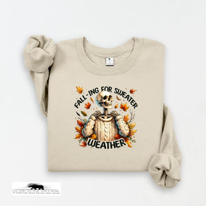 Beige sweatshirt with skeleton wearing a sweater and autumn leaves text on a white background