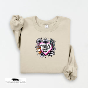 Beige sweatshirt with a graphic design featuring a heart, coffee cup, and books on a white background.