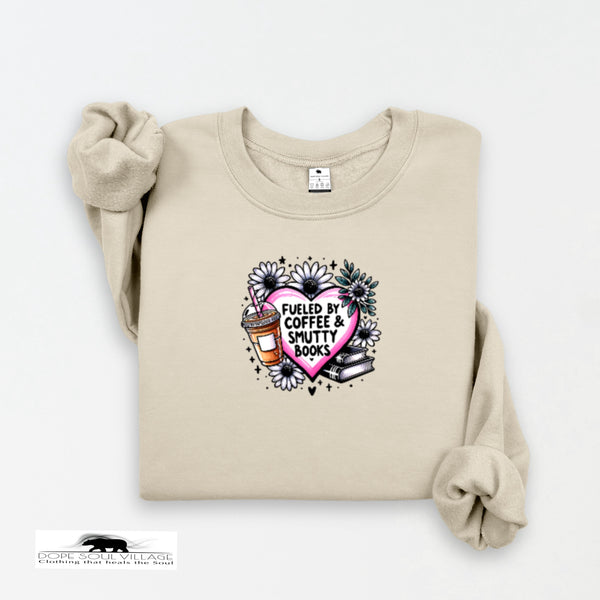 Beige sweatshirt with a graphic design featuring a heart, coffee cup, and books on a white background.