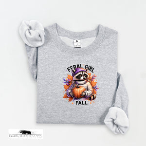 Gray sweatshirt with a raccoon holding a pumpkin and 'Feral Girl Fall' text on a white background.