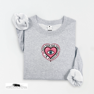 Gray sweatshirt with a pink heart design featuring an eye, on a white background.