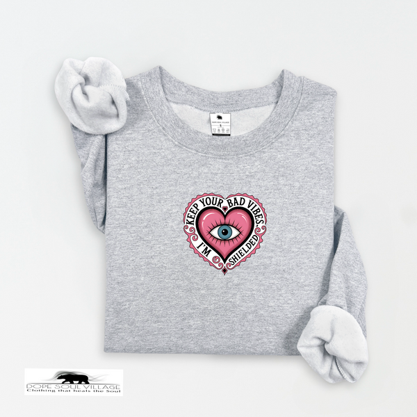 Gray sweatshirt with a pink heart design featuring an eye, on a white background.