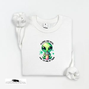White t-shirt with a green alien graphic and text on a white background