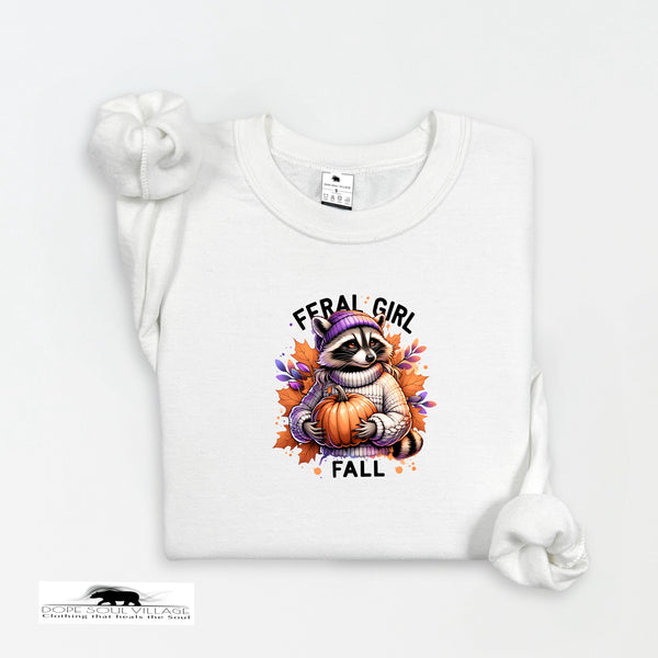 White t-shirt with a raccoon holding a pumpkin and 'Feral Girl Fall' text on a white background.