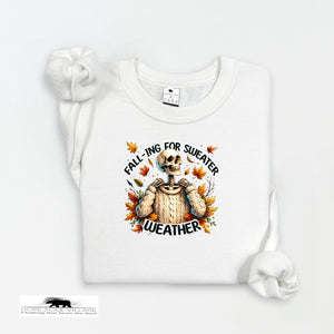 White sweatshirt with a skeleton wearing a sweater and autumn leaves design on a white background.
